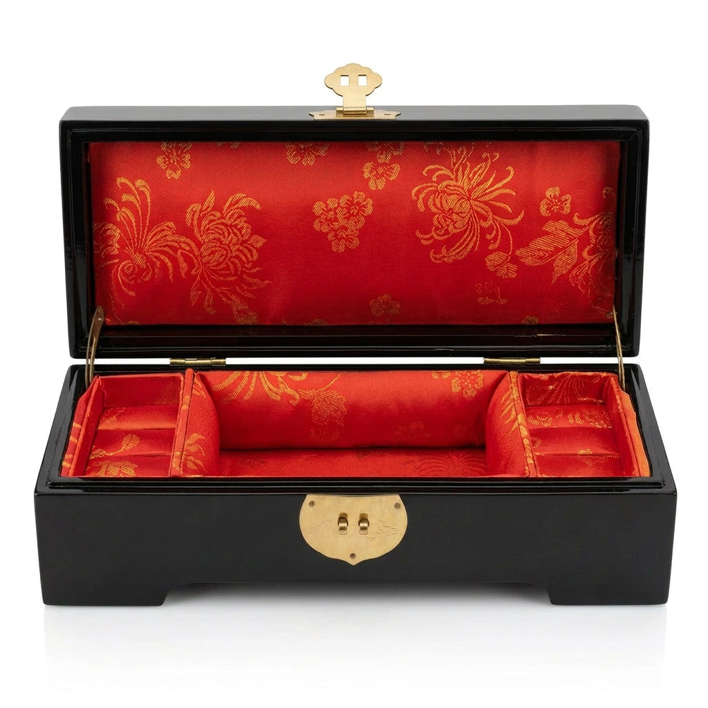 Boîte à bijoux chinoise noire ouverte, intérieur rouge à motifs dorés et compartiments latéraux.