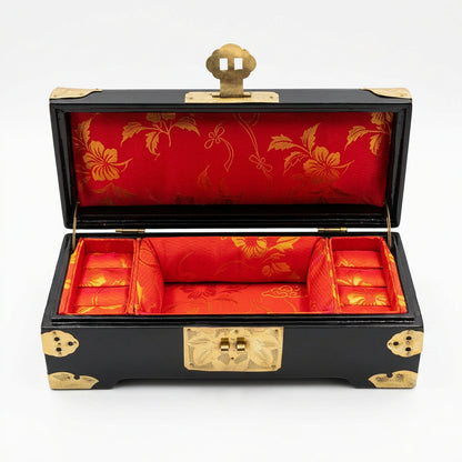 Boîte à bijoux chinoise noire ouverte sur fond blanc, intérieur rouge à motifs dorés et compartiments latéraux