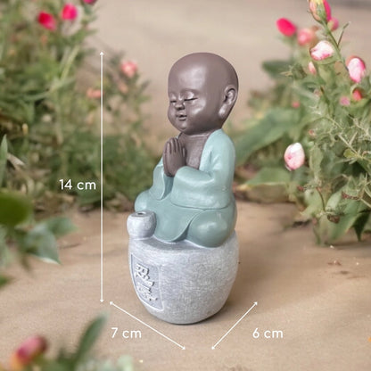 Figurine de petit moine assis, les mains jointes, avec dimensions indiquées : 14 × 7 × 6 cm.