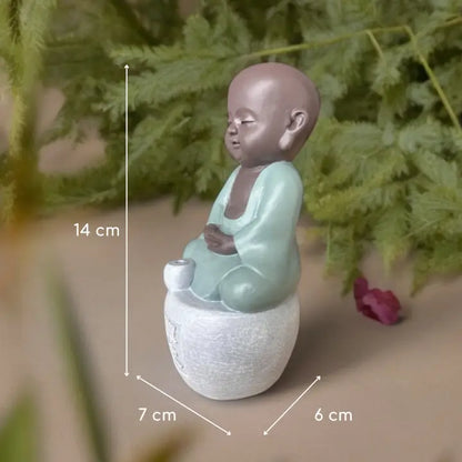 Figurine porte-encens de petit Bouddha en tenue vert clair, assis en méditation, avec dimensions indiquées : 14 × 7 × 6 cm